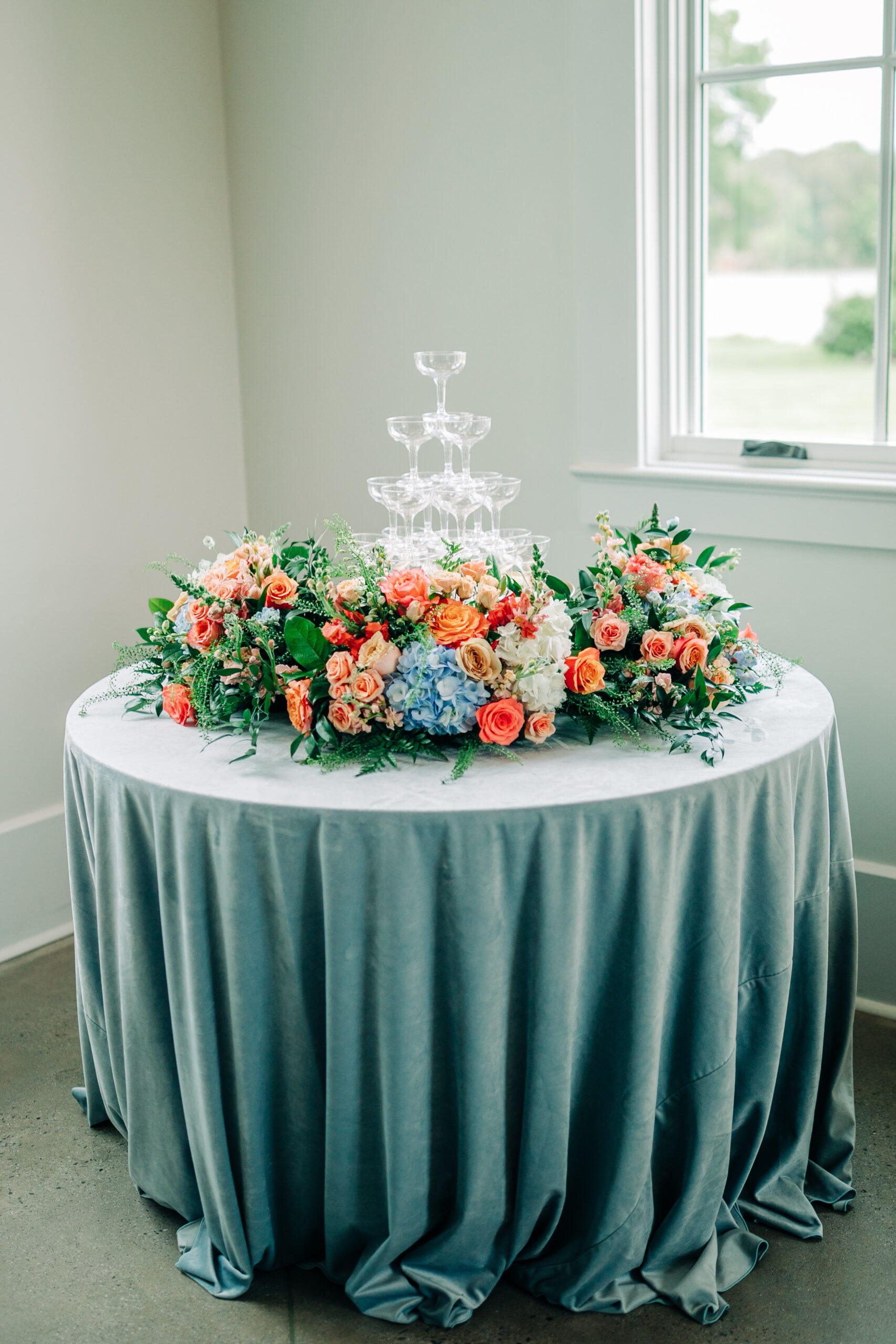 table with teal linens and floral arrangement