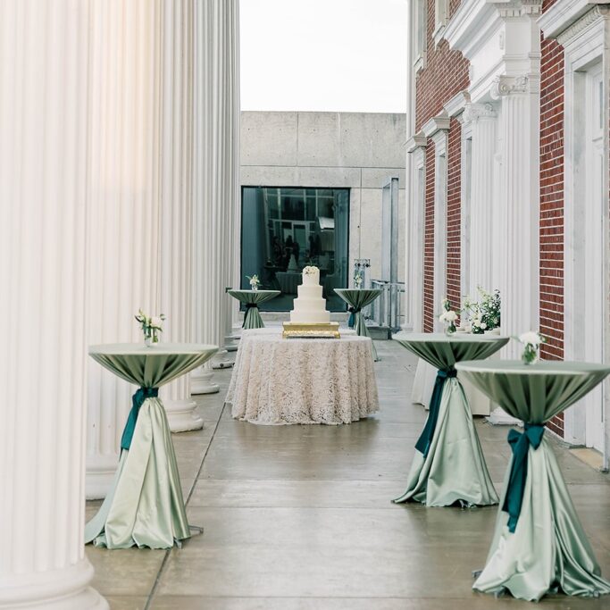 tall tables with green linens at outdoor event
